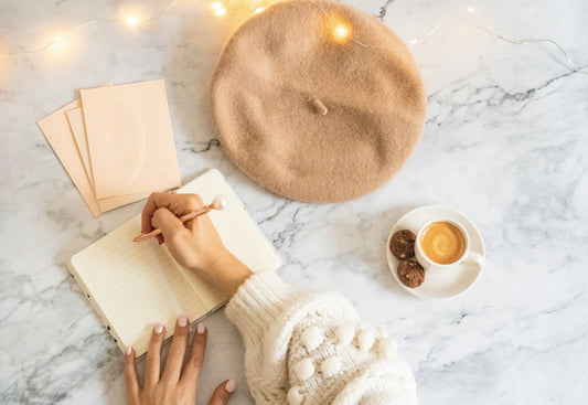 Writing a morning gratitude journal beside a cup of coffee.