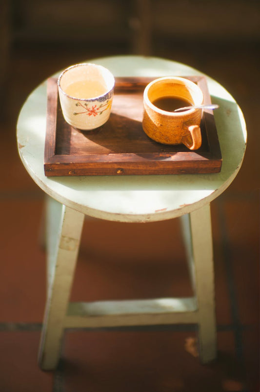 Cozy evening decaf coffee on a wooden tray with warm ambient light